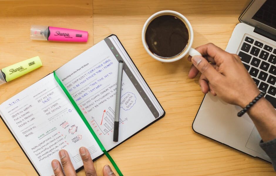 zapisany notes, kawa, zakreślacze i laptop