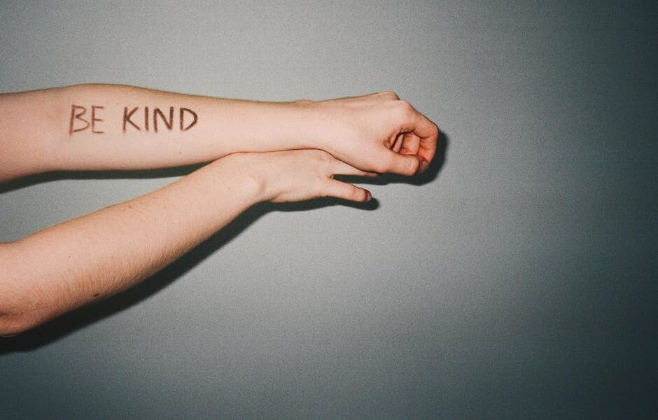 "BE KIND" napisane na ręce